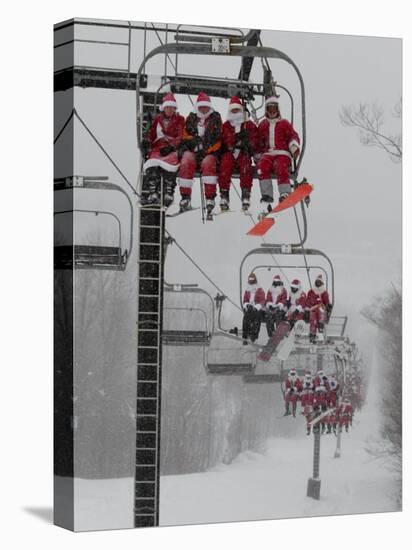 Skiers and Snowboarders Dressed as Santa Claus Ride up the Ski Lift-null-Premier Image Canvas