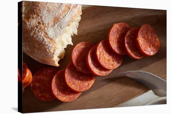 Sliced Pepperoni Shot Close On A Wooden Plate-Shea Evans-Stretched Canvas