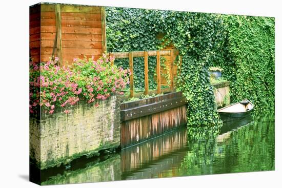 Small boat tied up in a canal next to a garden in Amsterdam.-Tom Haseltine-Premier Image Canvas