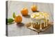 Small Orange Cake with White Icing on Wooden Table-Jana Ihle-Premier Image Canvas