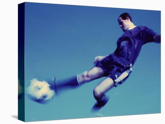 Soccer Player Jumping in Mid Air to Kick a Soccer Ball-null-Premier Image Canvas