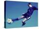 Soccer Player Jumping in Mid Air to Kick a Soccer Ball-null-Premier Image Canvas