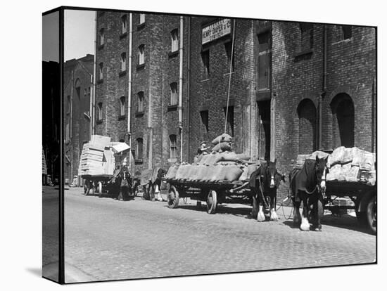 Stock Is Unloaded from Horse- Pulled Wagons and Drawn Up into the Warehouse by Rope-null-Premier Image Canvas