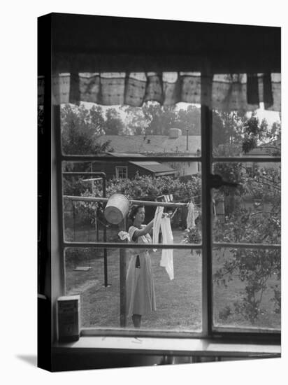 Suburban Housewife Hanging Out a Bit of Laundry, Seen Through Window in typical California Home-Loomis Dean-Premier Image Canvas