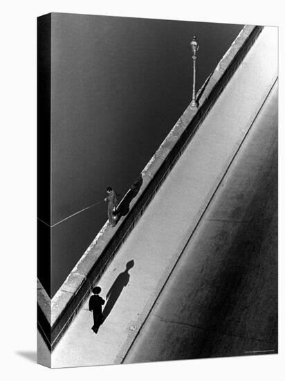 Sunday Morning Along the Arno River, a Man Fishing, and a Passerby Casting a Shadow-Alfred Eisenstaedt-Premier Image Canvas