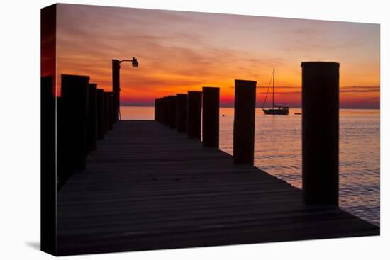 Sunrise on the Water with an Empty Dock and a Sailboat in the Distance of Tilghman Island, Maryland-Karine Aigner-Premier Image Canvas