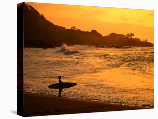 Surfer Standing at Waimea Bay at Sunset, Waimea, U.S.A.-Ann Cecil-Premier Image Canvas