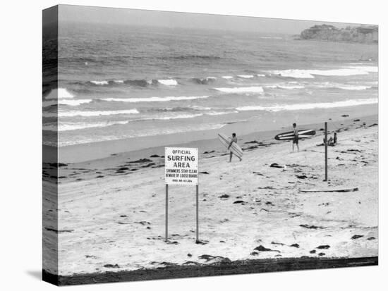 Surfers Walking to Water Behind Sign Reading "Official Surfing Area"-Allan Grant-Premier Image Canvas