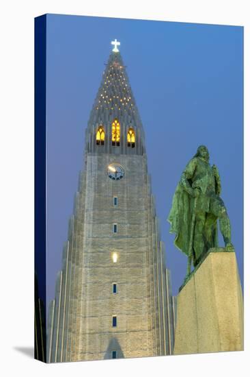 The Hallgrims Church with a statue of Leif Erikson in the foreground lit up at night, Reykjavik, Ic-Miles Ertman-Premier Image Canvas