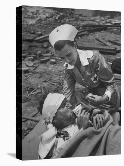 The Red Cross Nurse Trying to Help the Injured Man Eat and Drink-Allan Grant-Premier Image Canvas