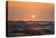 The sun setting over the landscape of hoodoos and hills of Badlands National Park.-Sheila Haddad-Premier Image Canvas
