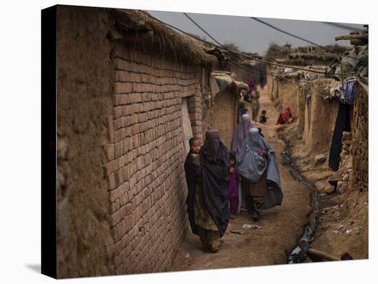 Three Afghan Refugee Women and their Children Walk in an Alley of a Poor Neighborhood in Pakistan-null-Premier Image Canvas