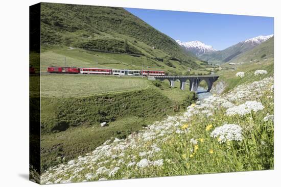 Typical red Swiss train on Hospental Viadukt surrounded by creek and blooming flowers, Andermatt, C-Roberto Moiola-Premier Image Canvas