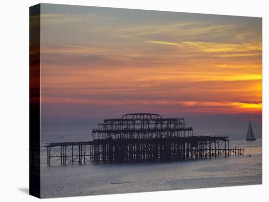 UK, England, Sussex, Brighton, Boat Sailing Past Remains of Brighton West Pier at Sunset-Jane Sweeney-Premier Image Canvas