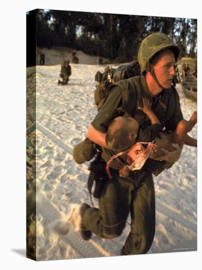 US Marine Medic Running Along Beach with Injured Vietnamese Infant under Fire During Vietnam War-Paul Schutzer-Premier Image Canvas