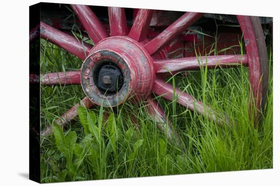 USA, Alaska, Chena Hot Springs. Vintage wagon wheel and grass.-Jaynes Gallery-Premier Image Canvas