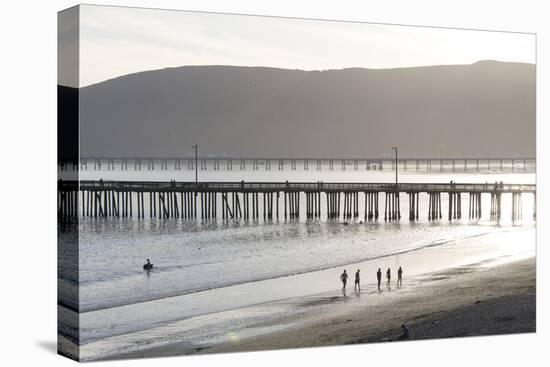 USA, California, Avila Beach. Silhouetted Beach Walkers Approach Pier End of Day-Trish Drury-Premier Image Canvas