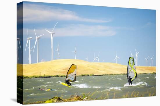 Usa, California, Rio Vista, Sacramento River Delta. Sailboarders with wind turbines.-Merrill Images-Premier Image Canvas