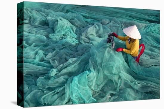 Vietnam. Fishing net analysis and repair with old fashioned manual sowing machine.-Tom Norring-Premier Image Canvas
