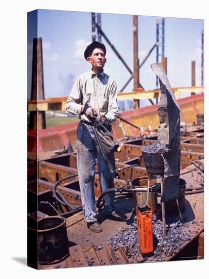 War Worker Holding Red Hot Metal Piece with Tongs at Shipyard-George Strock-Premier Image Canvas