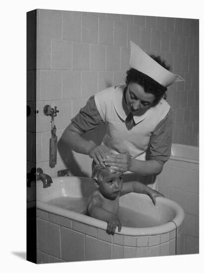 Woman Giving a Baby a Bath at a Nursery-null-Premier Image Canvas