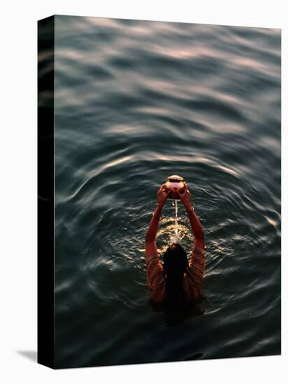 Woman Pouring Water During Morning Puja on Ganges, Varanasi, India-Anthony Plummer-Premier Image Canvas