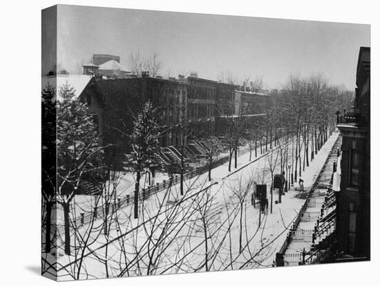 Woman sweeps snow off a snow-covered street lined with brownstones near two horse-drawn buggies.-George B^ Brainerd-Premier Image Canvas