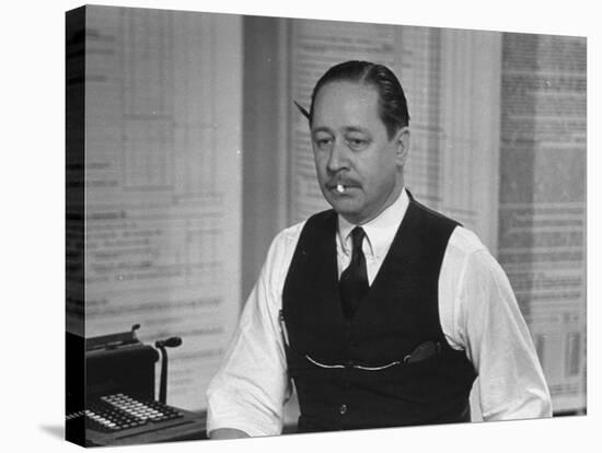 Writer Robert Benchley, Sitting at His Desk with a Small Wade of Paper in His Mouth-Bernard Hoffman-Premier Image Canvas