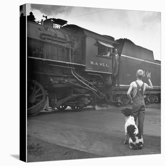 Young Boy and His Dog Standing at the Crossing as a Train Rides Through-Myron Davis-Premier Image Canvas