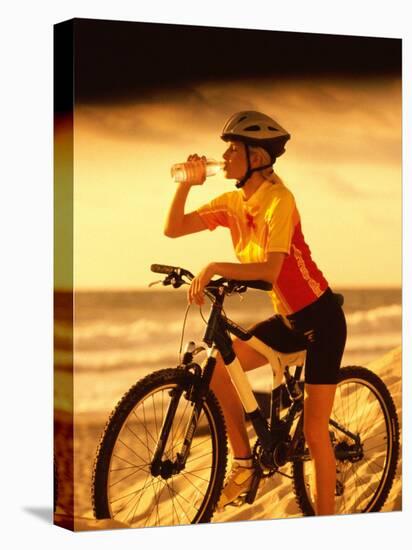 Young Woman Drinking Water Sitting on a Bicycle-null-Premier Image Canvas