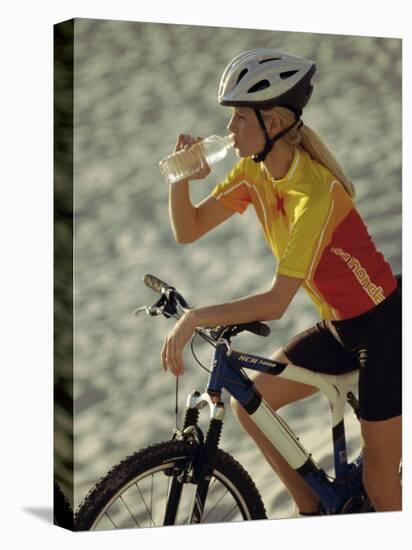Young Woman Drinking Water While Sitting on a Bicycle-null-Premier Image Canvas