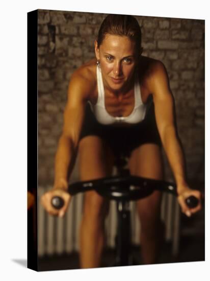 Young Woman Exercising on a Stationary Bike-null-Premier Image Canvas