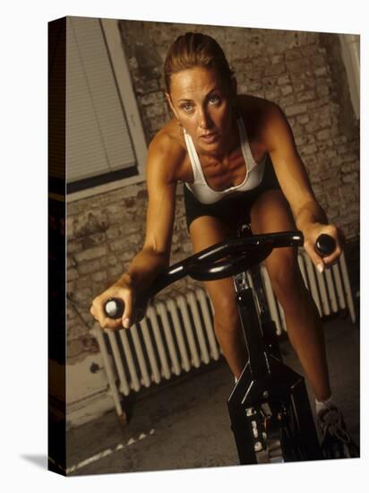 Young Woman Exercising on a Stationary Bike-null-Premier Image Canvas