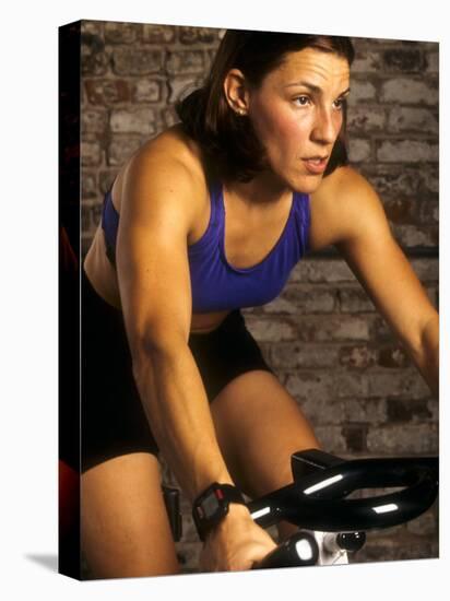 Young Woman Exercising on a Stationary Bike-null-Premier Image Canvas