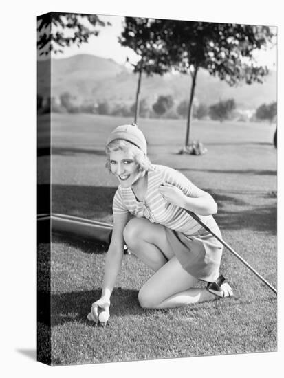 Young Woman on a Golf Course Placing a Golf Ball-null-Stretched Canvas
