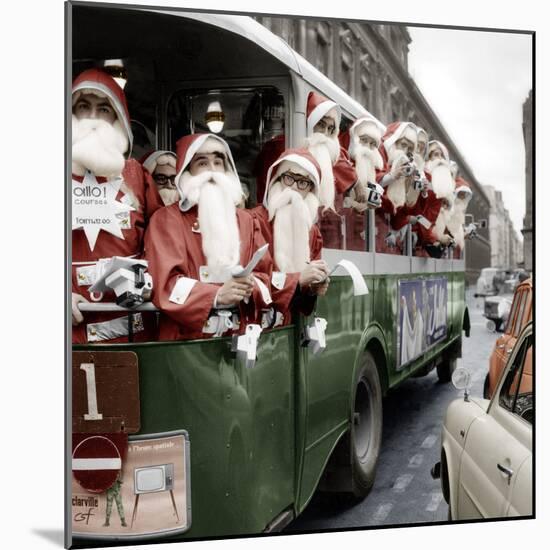 100 Santa Claus in a Special Bus in Paris December, 19, 1966. Colorized Document-null-Mounted Photo