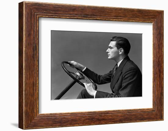 1930s 1940s MAN WEARING SUIT AND TIE DRIVING HANDS ON STEERING WHEEL-H. Armstrong Roberts-Framed Photographic Print