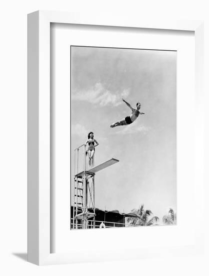 1930s 1940s SHAPELY WOMAN WATCHING MAN SWAN DIVE OFF HIGH DIVING BOARD-H. Armstrong Roberts-Framed Photographic Print