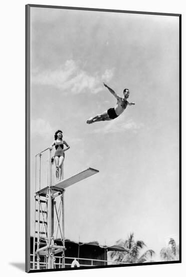 1930s 1940s SHAPELY WOMAN WATCHING MAN SWAN DIVE OFF HIGH DIVING BOARD-H. Armstrong Roberts-Mounted Photographic Print