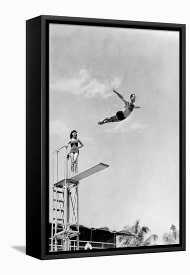 1930s 1940s SHAPELY WOMAN WATCHING MAN SWAN DIVE OFF HIGH DIVING BOARD-H. Armstrong Roberts-Framed Premier Image Canvas