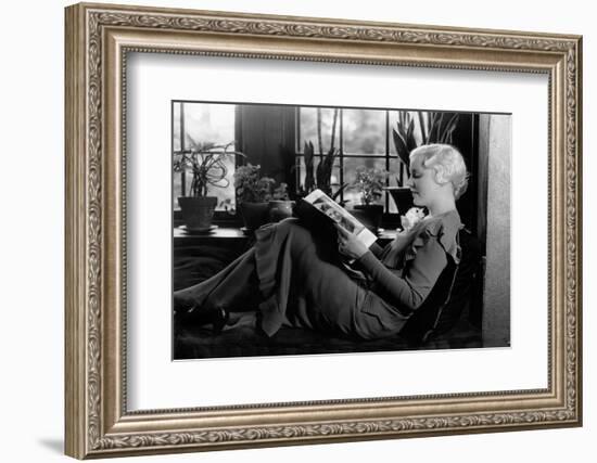 1930s BLOND WOMAN SITTING BY WINDOW READING MAGAZINE PROFILE VIEW PLANTS IN BACKGROUND WINDOW SEAT-H. Armstrong Roberts-Framed Photographic Print