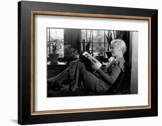 1930s BLOND WOMAN SITTING BY WINDOW READING MAGAZINE PROFILE VIEW PLANTS IN BACKGROUND WINDOW SEAT-H. Armstrong Roberts-Framed Photographic Print