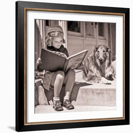 1930s ENGROSSED LITTLE GIRL OUTDOOR READING BIG BOOK SITTING NEXT TO ROUGH COLLIE DOG LOOKING AT...-H. Armstrong Roberts-Framed Photographic Print