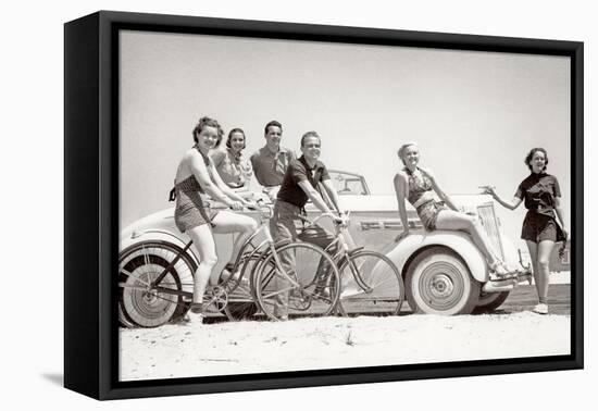 1930s GROUP OF MEN AND WOMEN WEARING BATHING SUITS CASUAL CLOTHES ON BICYCLES IN A CAR ON BEACH...-H. Armstrong Roberts-Framed Premier Image Canvas