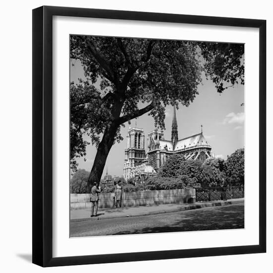 1950s Paris, France Tourist Couple Man with Camera Photographing Woman Notre Dame Cathedral-null-Framed Photographic Print