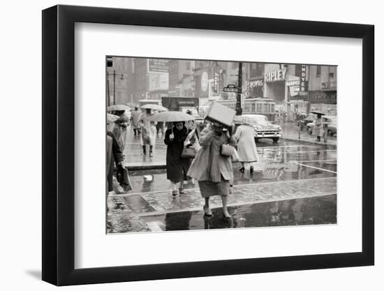 1950s PEDESTRIANS WOMAN HOLDING BOX OVER HEAD CAUGHT IN SUDDEN RAIN STORM 12TH & MARKET STREETS...-H. Armstrong Roberts-Framed Photographic Print