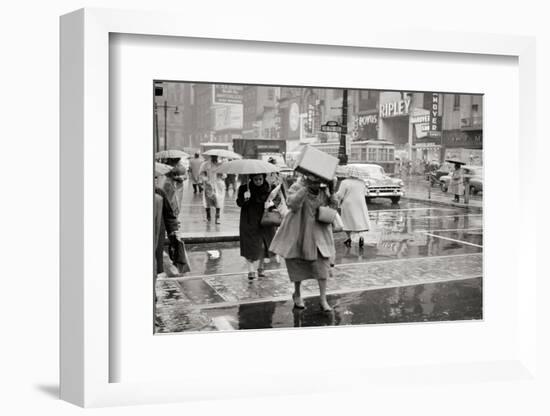 1950s PEDESTRIANS WOMAN HOLDING BOX OVER HEAD CAUGHT IN SUDDEN RAIN STORM 12TH & MARKET STREETS...-H. Armstrong Roberts-Framed Photographic Print