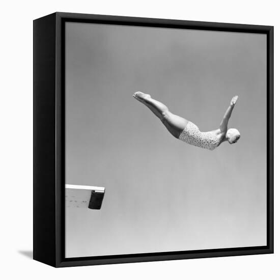 1950s WOMAN SWAN DIVE OFF DIVING BOARD ONE PIECE BATHING SUIT AND SWIMMING CAP-H. Armstrong Roberts-Framed Premier Image Canvas