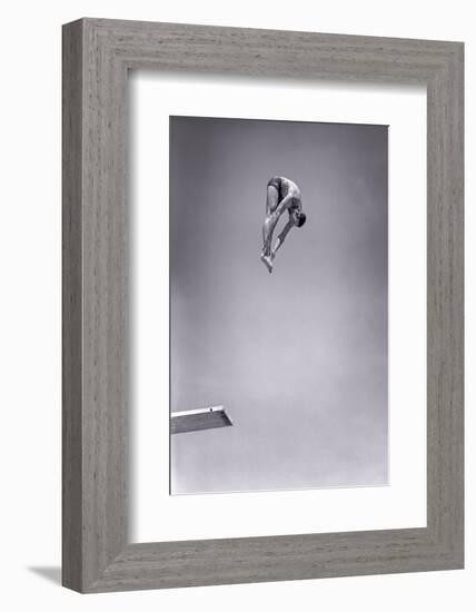 1960s MAN JUMPING OFF DIVING BOARD TOUCHING TOES DOING FORWARD DIVE IN THE PIKE POSITION-H. Armstrong Roberts-Framed Photographic Print