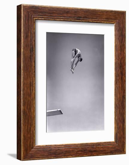 1960s MAN JUMPING OFF DIVING BOARD TOUCHING TOES DOING FORWARD DIVE IN THE PIKE POSITION-H. Armstrong Roberts-Framed Photographic Print